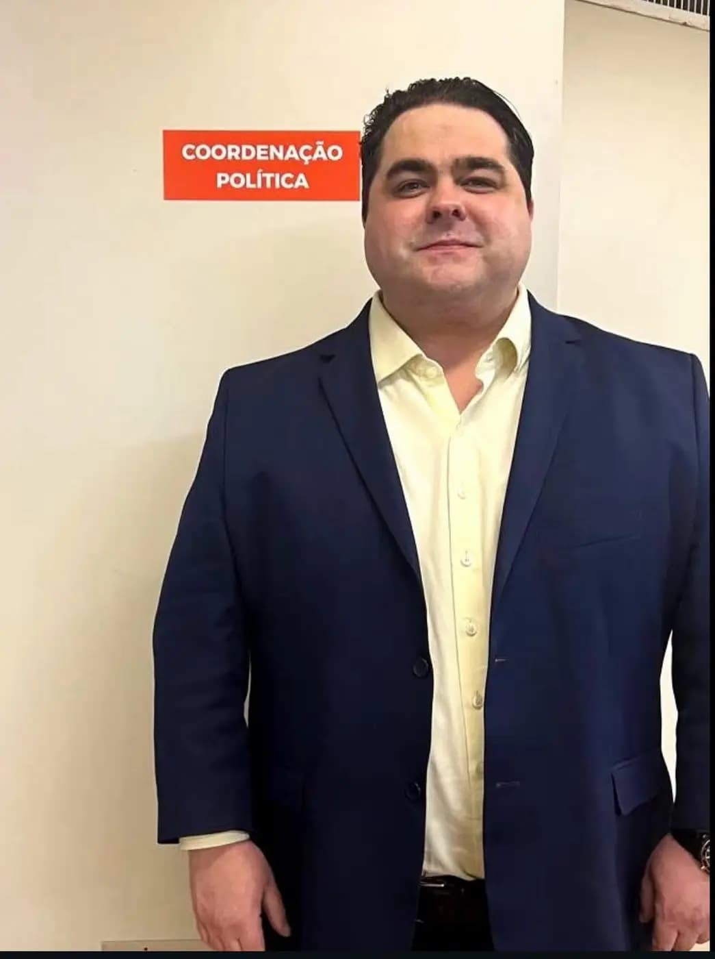 Mateus Gomes em pé, usando paletó azul e camisa branca