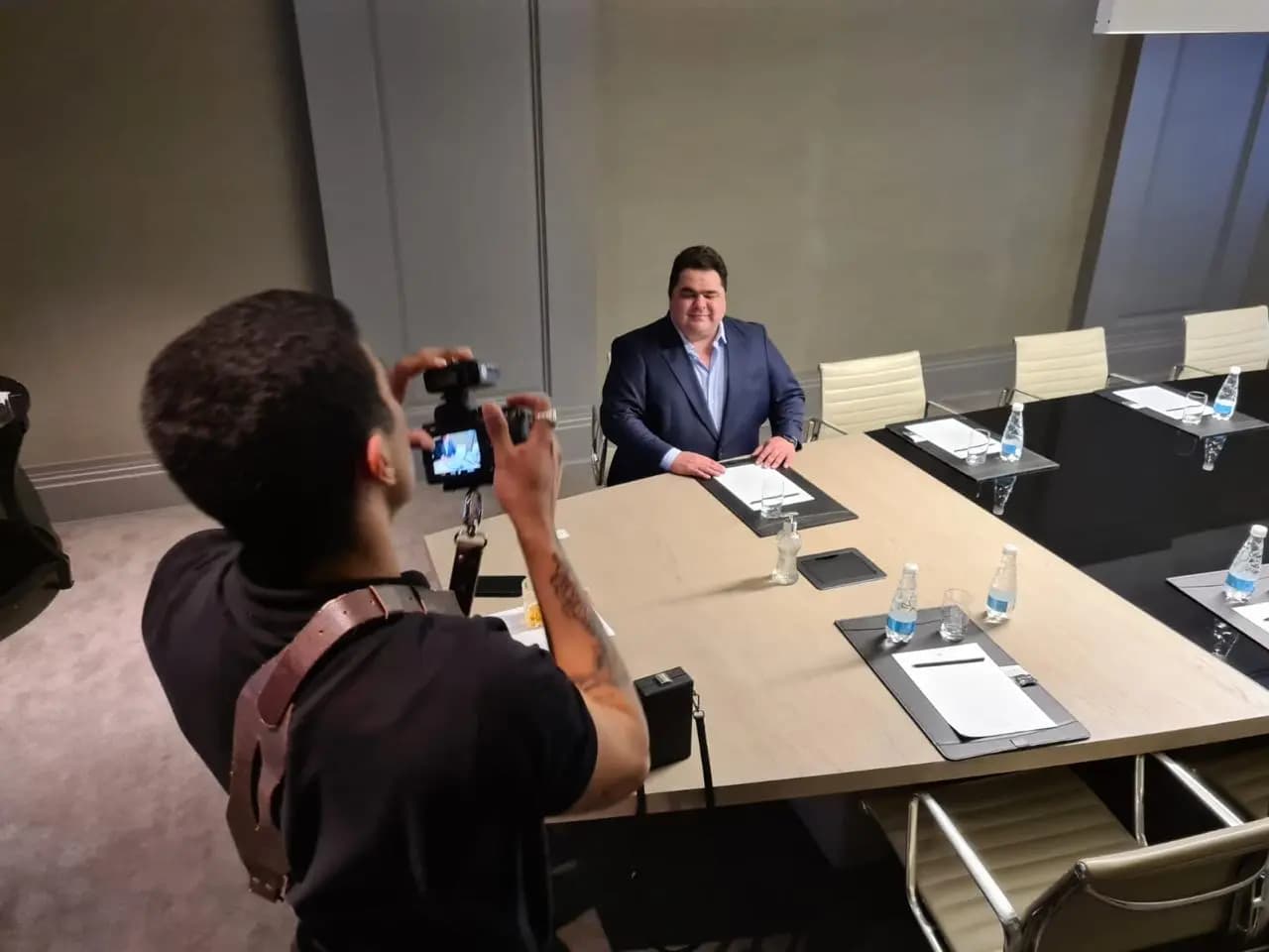 Mateus Gomes sendo fotografado em uma sala de reuniões